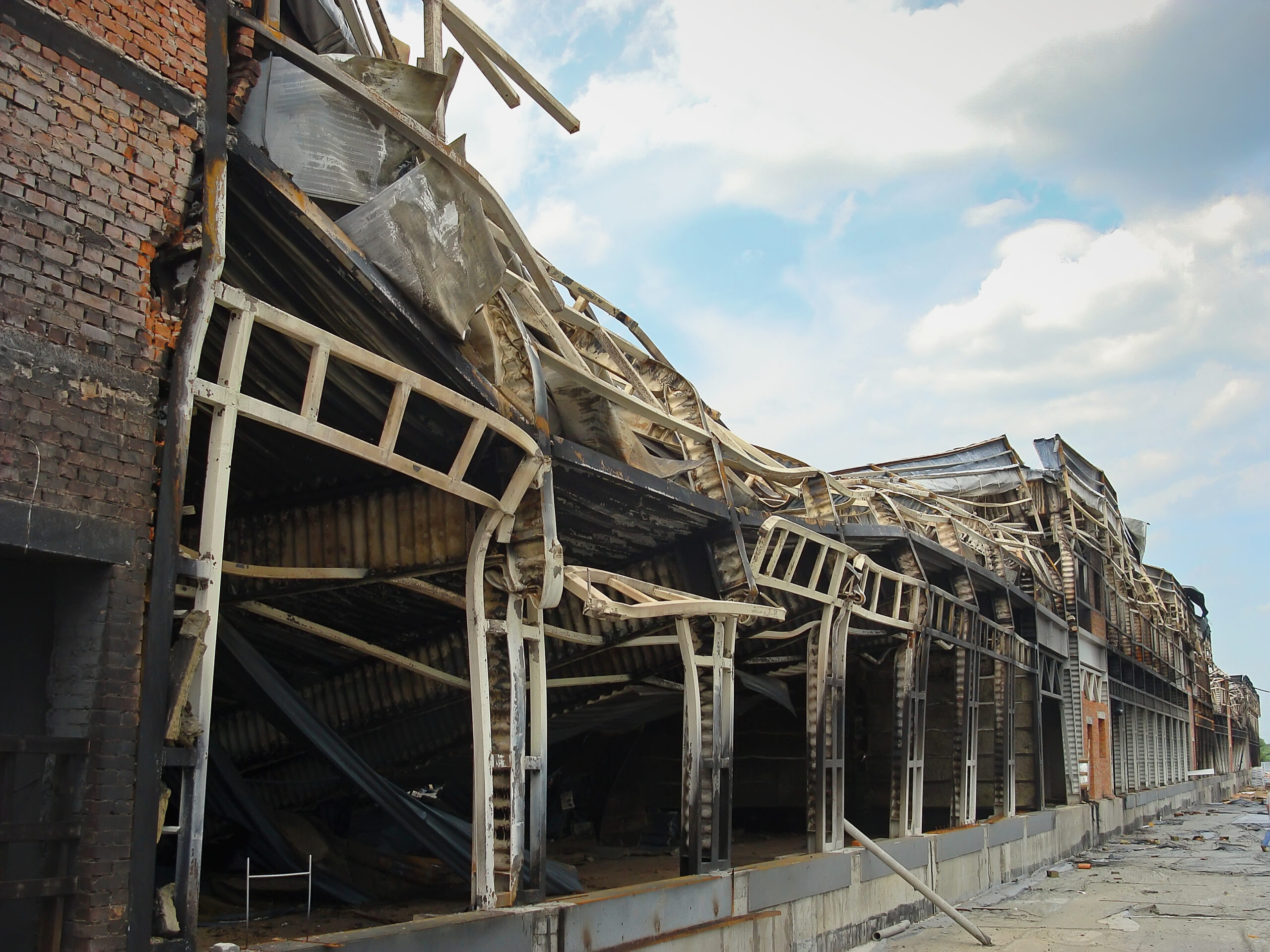 A commercial warehouse structure with its roof collapsed from fire damage